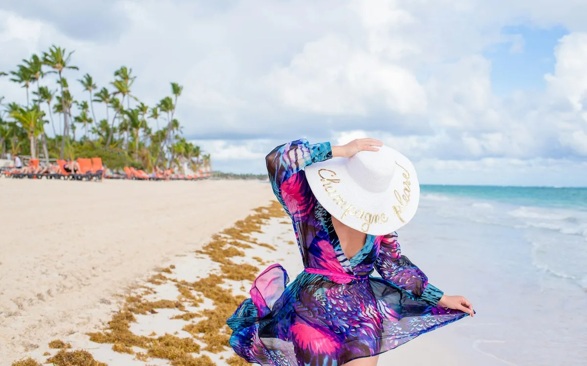 Chica con sombrero blanco en la playa